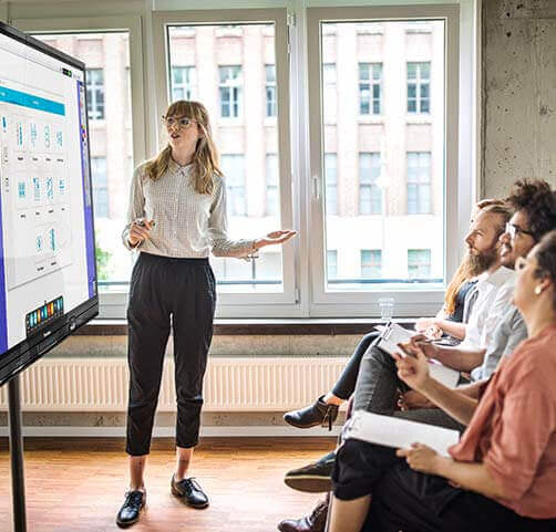 woman giving presentation on an ActivPanel in a business office. 