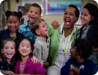 teacher laughing with young students