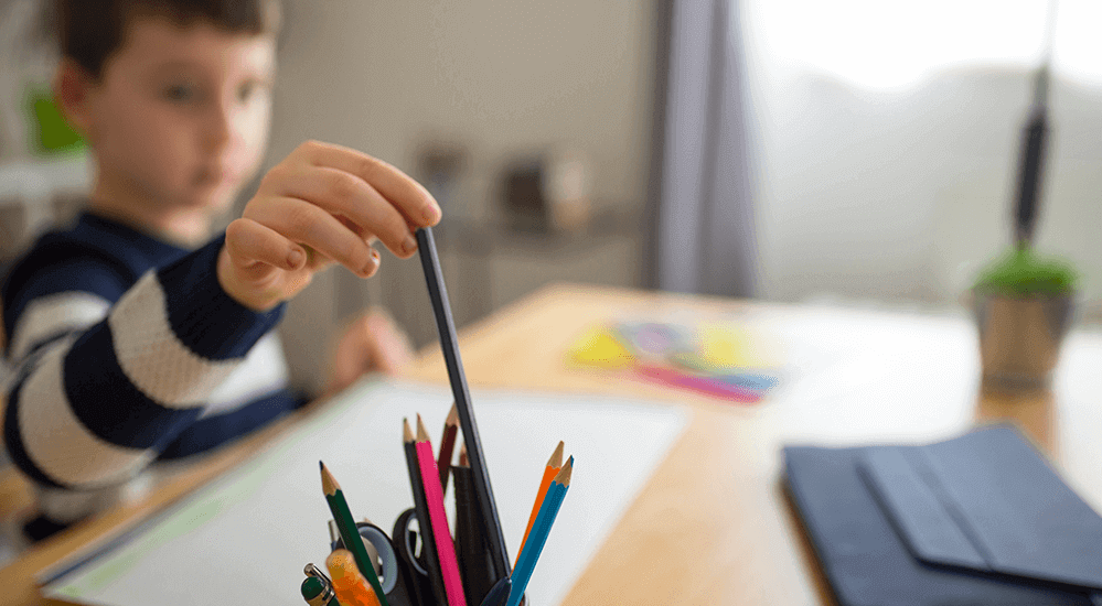 student reaching for pencil