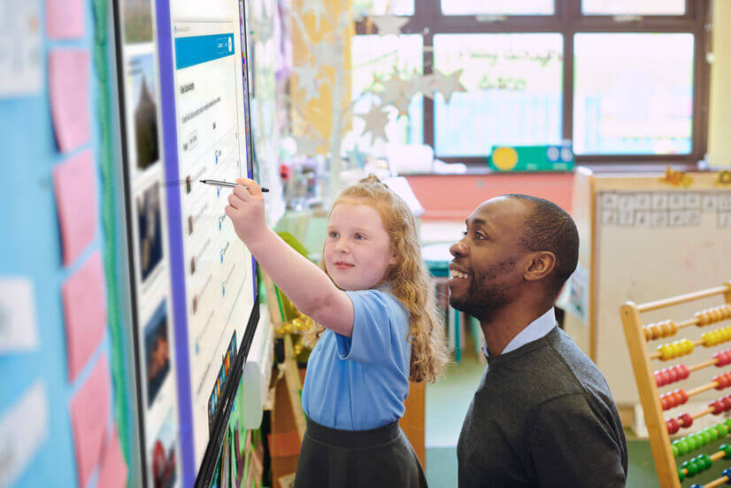 Teacher helping student through a lesson on the Promethean ActivPanel. 