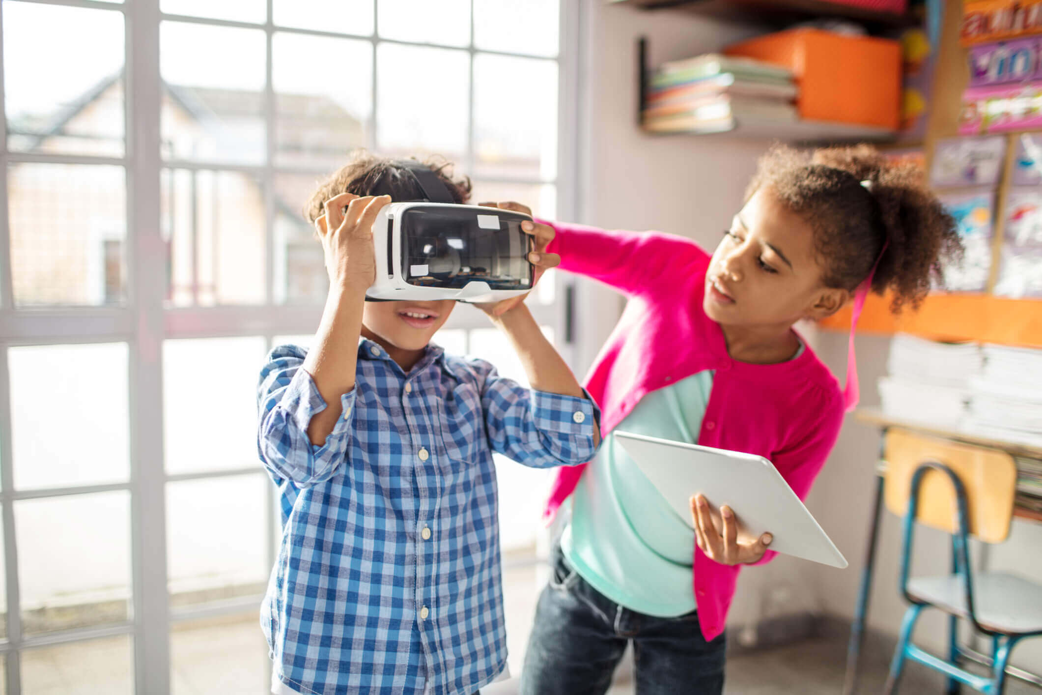 Deux élèves travaillent ensemble en utilisant un casque pour la réalité virtuelle et une tablette pour la réalité augmentée.