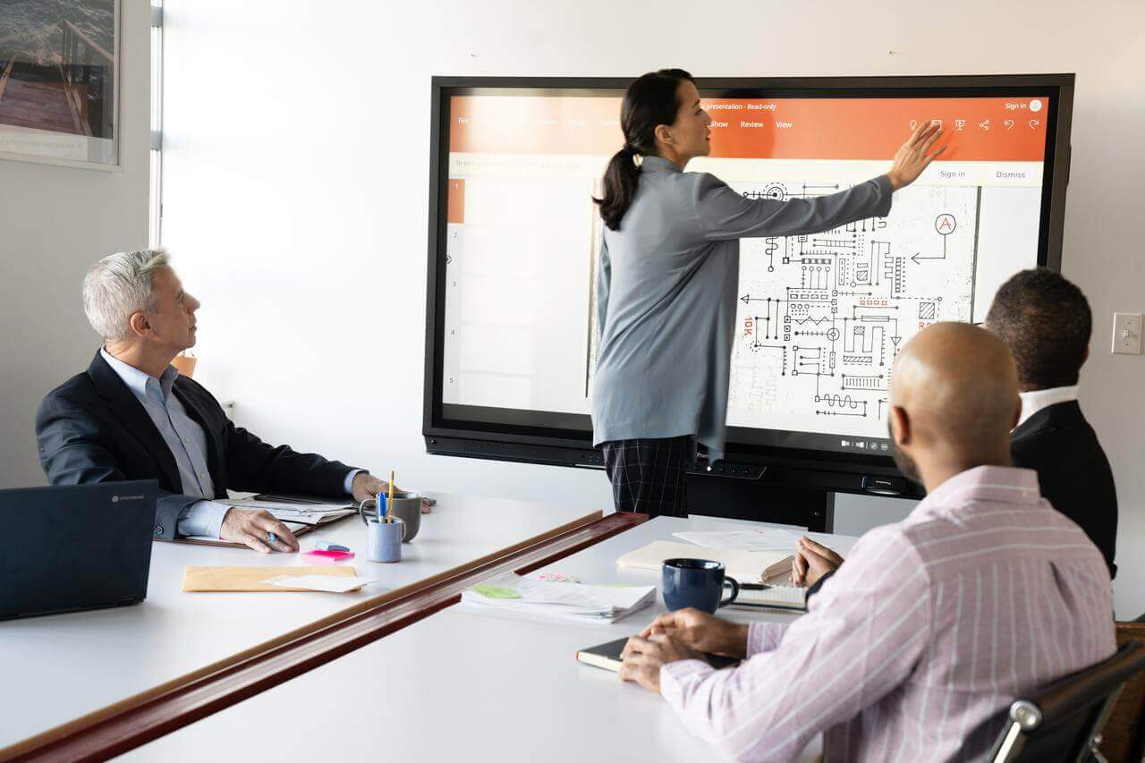 A team collaboration exercise showing an employee presenting to a room of peers