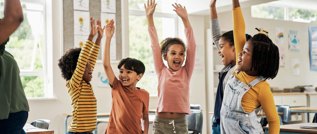 Kinder spielen ein Kennenlernspiel und zeigen auf.